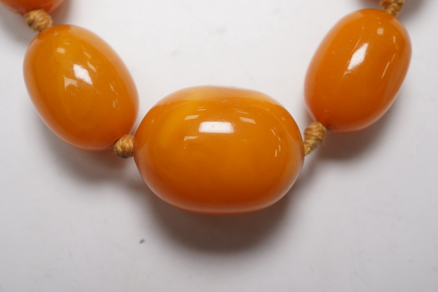 A single strand graduated oval amber bead necklace, 62cm, gross weight 34 grams. Condition - poor to fair